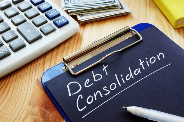 debt consolidation inscription on a black page and clipboard.