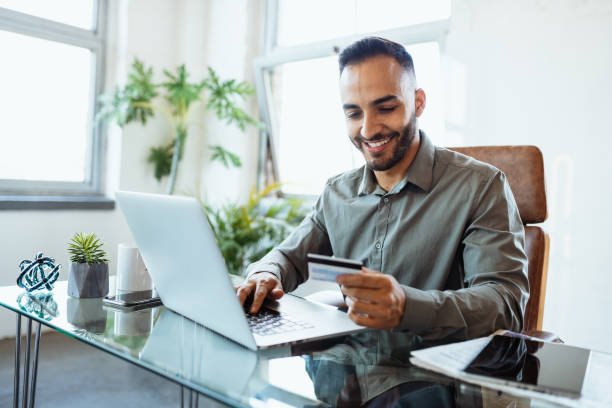 mid adult latin businessman in office, working on laptop